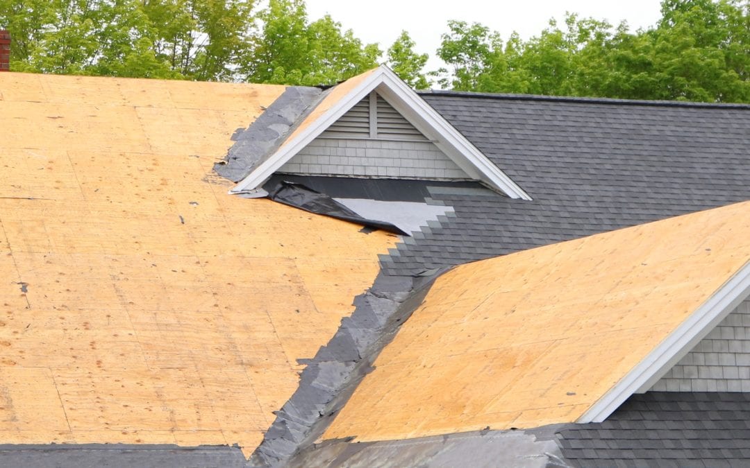 Metal roofing over existing shingle roof page image. Image shows a roof being stripped of existing shingles.